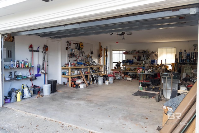 garage with a workshop area and electric panel