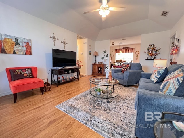 living room featuring ceiling fan, a tray ceiling, vaulted ceiling, and wood-type flooring