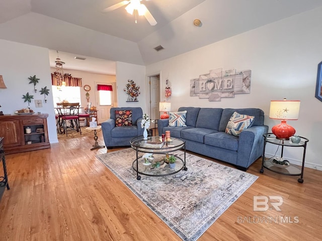 living room with ceiling fan, vaulted ceiling, and hardwood / wood-style flooring