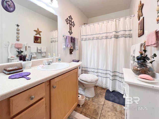 bathroom featuring toilet, tile patterned floors, and vanity