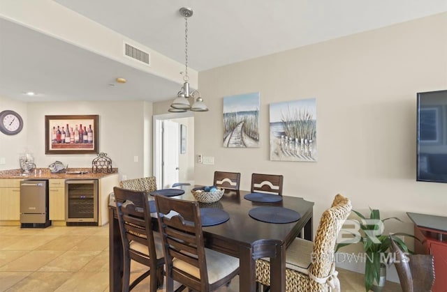 tiled dining area featuring an inviting chandelier and beverage cooler