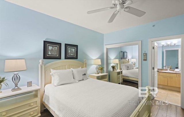 bedroom with ceiling fan, dark hardwood / wood-style floors, ensuite bathroom, a closet, and sink