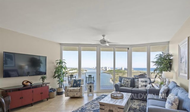 living room with a water view, ceiling fan, light tile patterned floors, and plenty of natural light