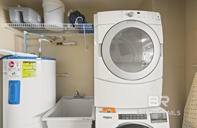 washroom with sink, water heater, and stacked washer and clothes dryer