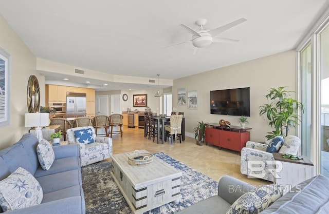 living room featuring ceiling fan and a healthy amount of sunlight