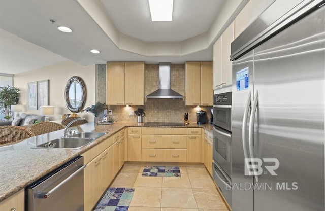 kitchen featuring wall chimney range hood, light brown cabinets, light tile patterned floors, appliances with stainless steel finishes, and sink