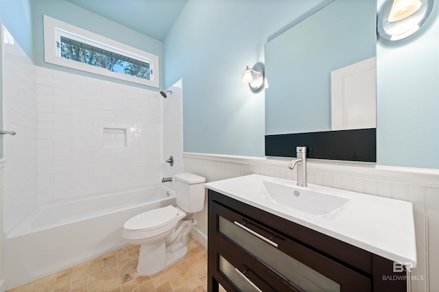 bathroom featuring a wainscoted wall, shower / washtub combination, vanity, and toilet