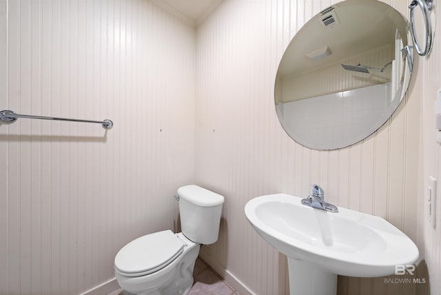 bathroom with a sink, toilet, and baseboards