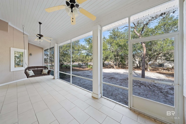 unfurnished sunroom featuring ceiling fan, plenty of natural light, and vaulted ceiling