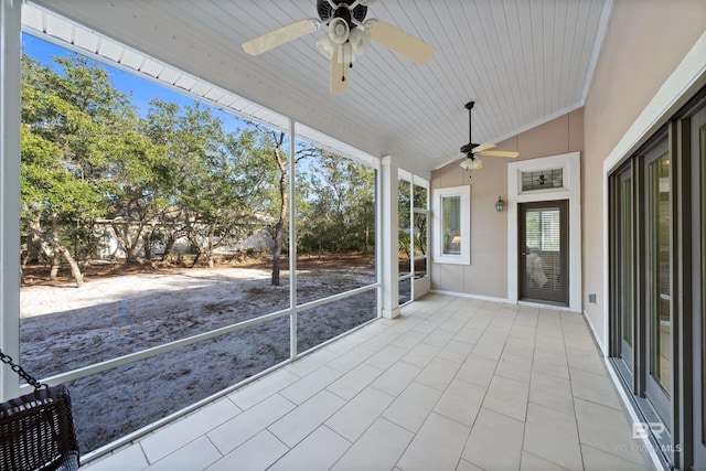 unfurnished sunroom featuring vaulted ceiling and a ceiling fan