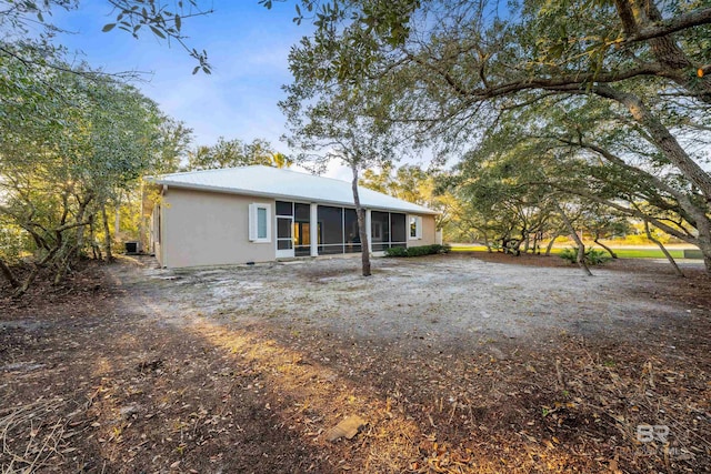 back of house with a sunroom and metal roof