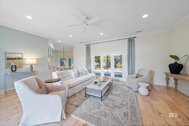 living room featuring ornamental molding, french doors, baseboards, and wood finished floors