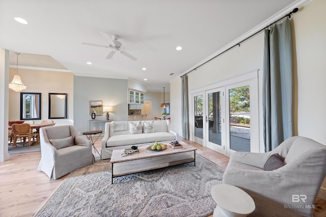 living area with french doors, crown molding, recessed lighting, ceiling fan, and light wood-type flooring