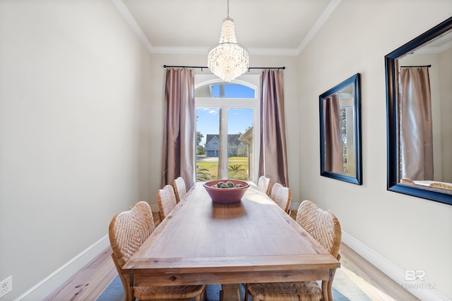 dining area featuring ornamental molding, a chandelier, baseboards, and wood finished floors