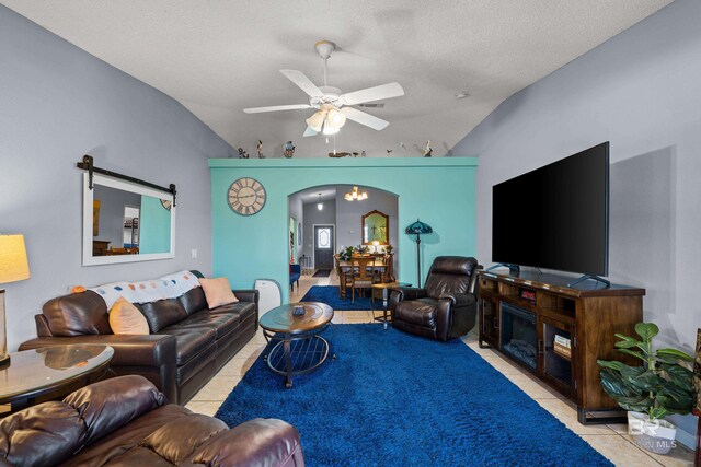living room featuring arched walkways, tile patterned flooring, ceiling fan, and vaulted ceiling