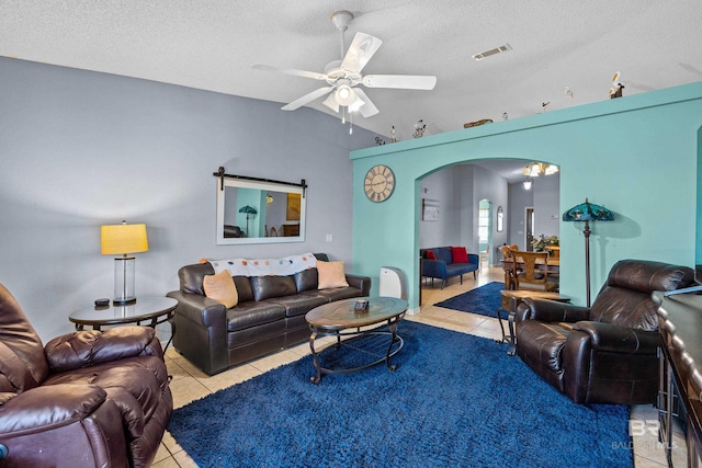 living room with arched walkways, visible vents, tile patterned floors, and a textured ceiling