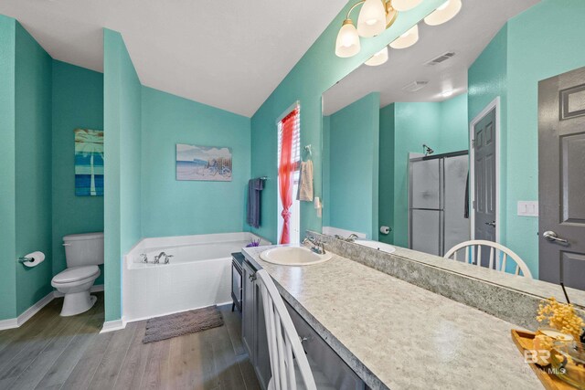 full bath with visible vents, a garden tub, toilet, wood finished floors, and a shower stall