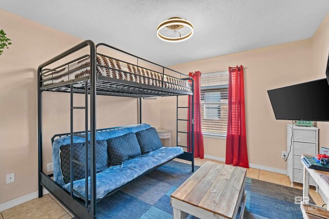 bedroom featuring tile patterned floors and baseboards