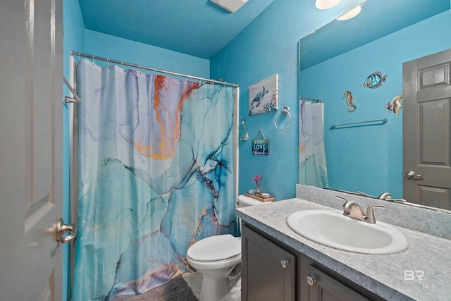 full bath with vanity, curtained shower, toilet, and a textured wall