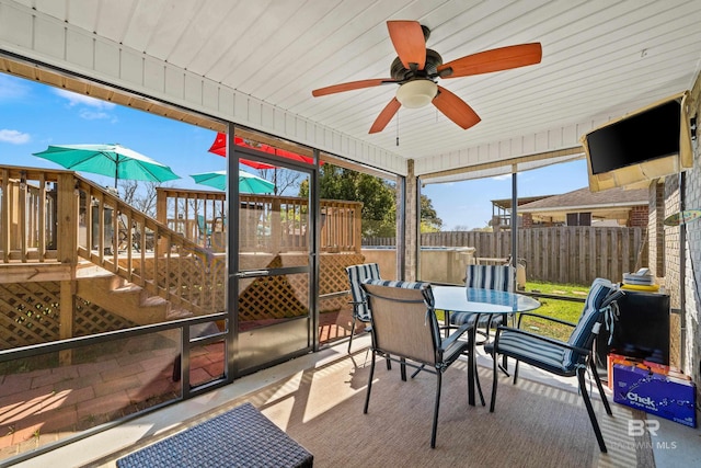 sunroom / solarium with outdoor dining space and a ceiling fan