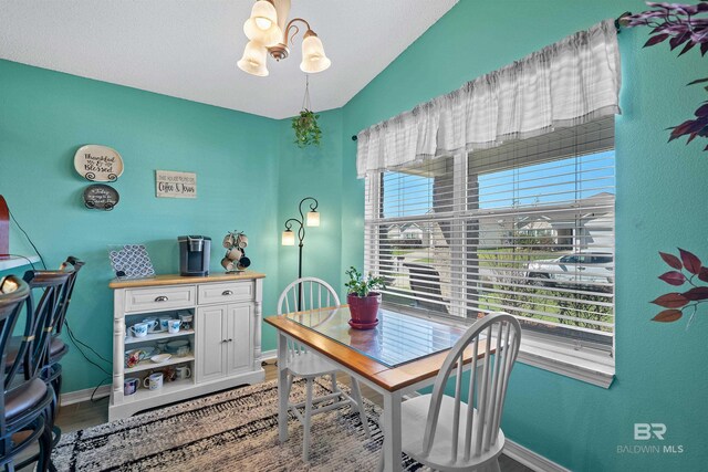 dining room featuring an inviting chandelier, baseboards, and light wood-type flooring