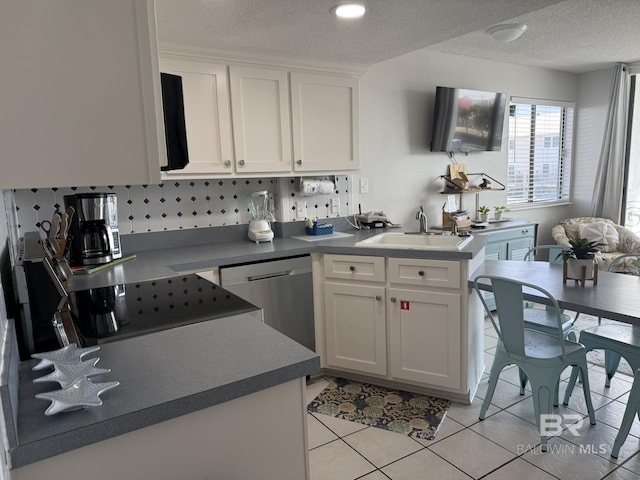 kitchen with a sink, stainless steel dishwasher, a textured ceiling, white cabinetry, and light tile patterned floors