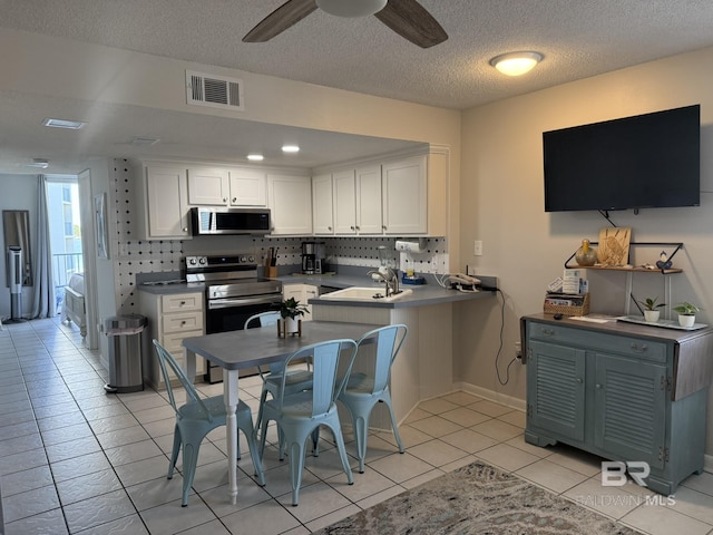 kitchen with stainless steel appliances, visible vents, decorative backsplash, and white cabinetry