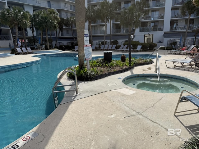 community pool featuring a patio area and a hot tub