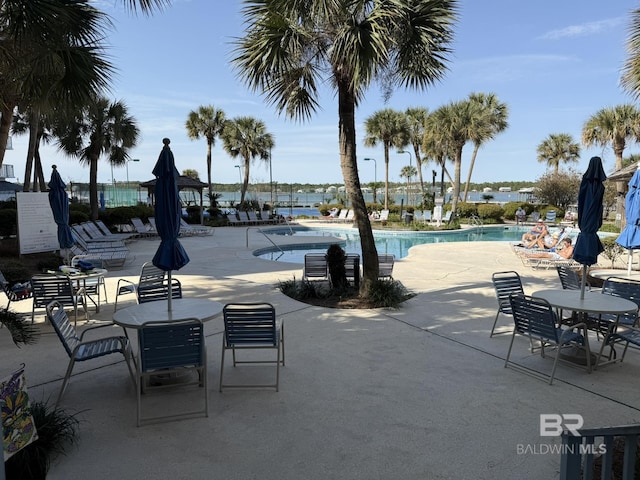 community pool featuring a patio area and a water view