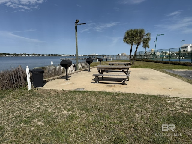 surrounding community with fence and a water view