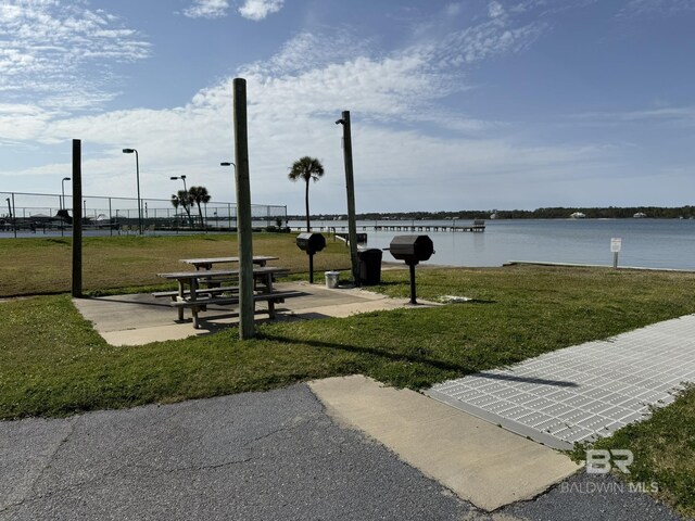 view of property's community featuring a yard and a water view