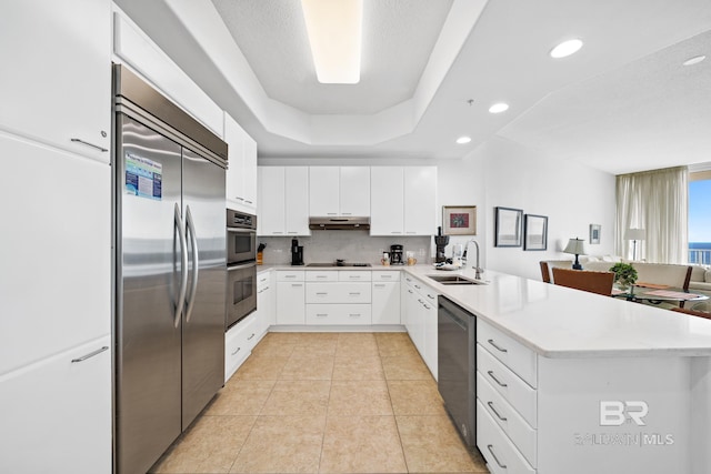 kitchen with stainless steel appliances, white cabinets, light countertops, and a sink