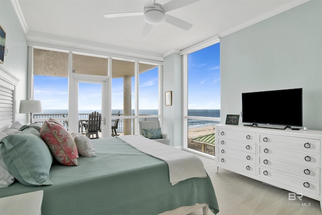 bedroom featuring crown molding, multiple windows, a wall of windows, and carpet flooring