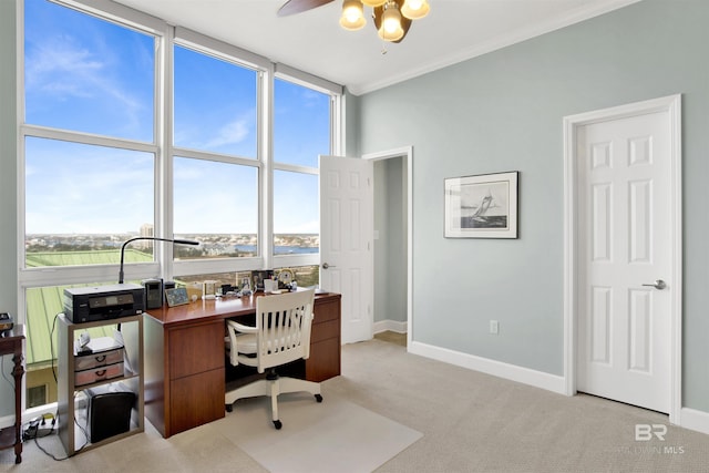 office area with baseboards, floor to ceiling windows, crown molding, and light colored carpet