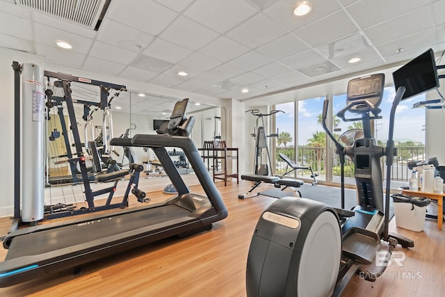 gym featuring visible vents, a drop ceiling, and wood finished floors