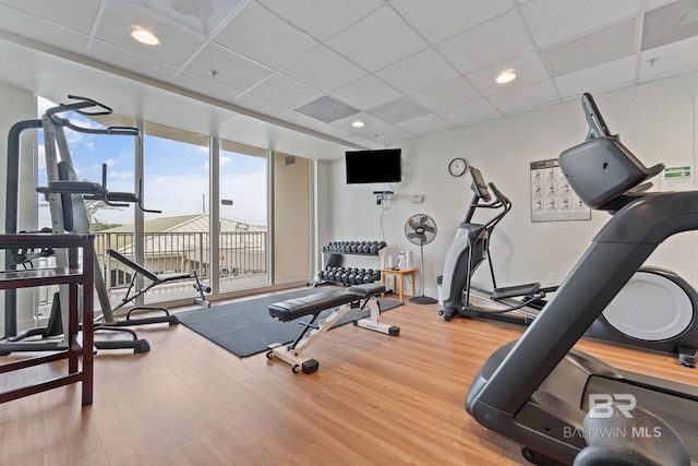 workout room with a drop ceiling and wood finished floors