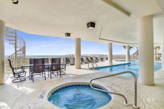 pool featuring a patio area, a hot tub, and stairs