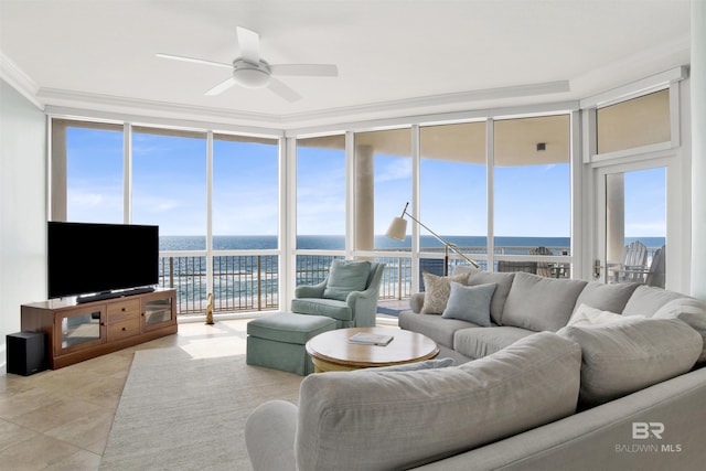 living area featuring light tile patterned floors, plenty of natural light, ornamental molding, a water view, and expansive windows