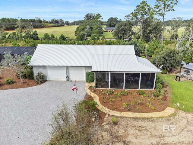 view of front of property with metal roof, a front lawn, and a sunroom