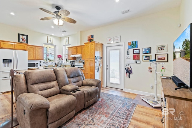 living area featuring baseboards, visible vents, a ceiling fan, light wood-style floors, and recessed lighting