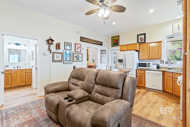 living room featuring light wood-type flooring, visible vents, ceiling fan, and recessed lighting