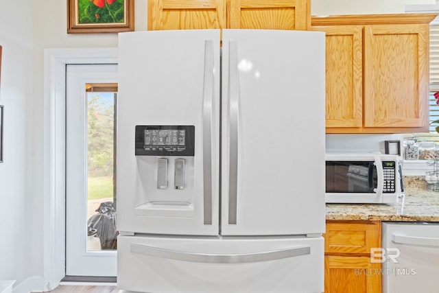 kitchen with white appliances and light stone countertops