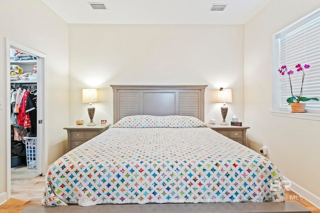 bedroom featuring visible vents, a spacious closet, and multiple windows