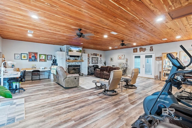 living room with french doors, recessed lighting, wood ceiling, a stone fireplace, and wood finished floors