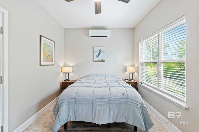 bedroom with ceiling fan, baseboards, and a wall mounted AC
