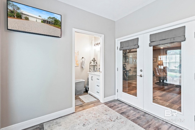 entryway with baseboards, wood finished floors, and french doors