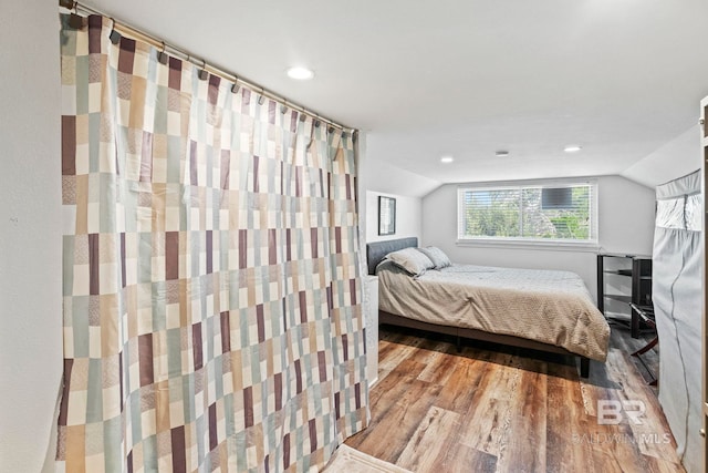 bedroom featuring lofted ceiling, wood finished floors, and recessed lighting