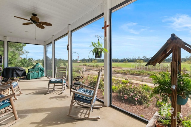 sunroom / solarium featuring a ceiling fan