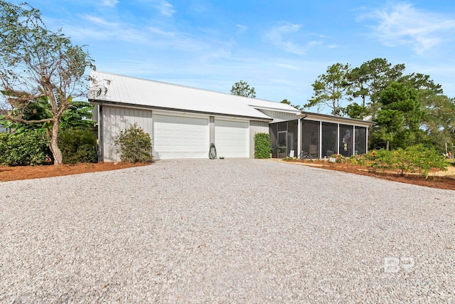 view of front facade featuring a sunroom and a detached garage
