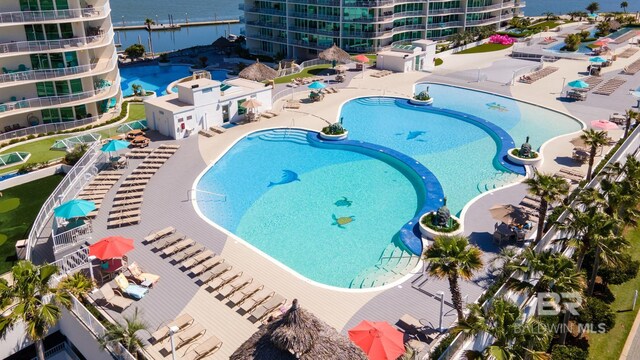 community pool with a patio area and a water view